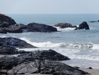 Scenic view of rocks in sea against sky