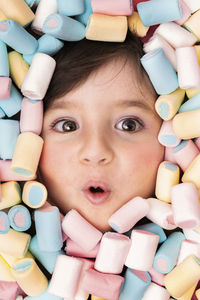 Girl face surrounded with marshmallow looking surprised