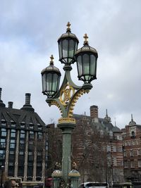 Low angle view of street light against cloudy sky in london