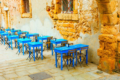 Empty chairs and tables in front of building