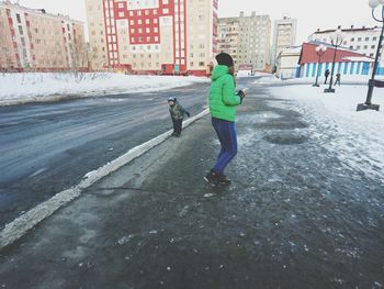 Full length of boy on snow in city