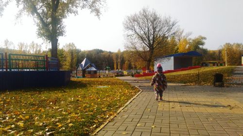 Boy in park against sky during autumn