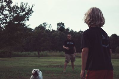 Father and son with english bulldog in park