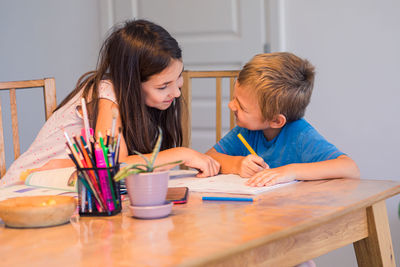 Friends sitting on table at home