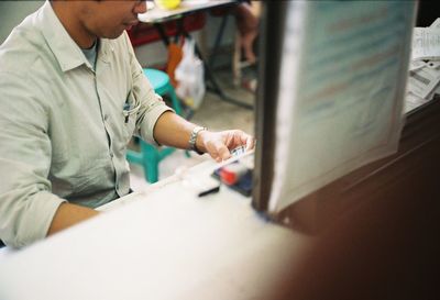 Close-up of man with mobile phone on table