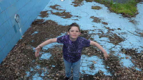 High angle portrait of girl standing against blue sky