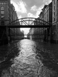 Bridge over river amidst buildings in city