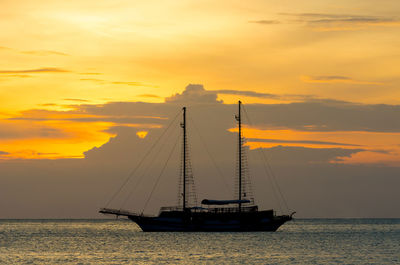 Silhouette sailboat on sea against sky during sunset