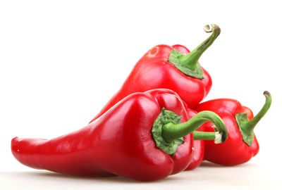 Close-up of red bell peppers against white background