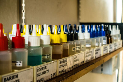 Close-up of multi colored bottles in shelf