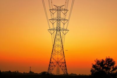 Low angle view of silhouette electricity pylon against romantic sky