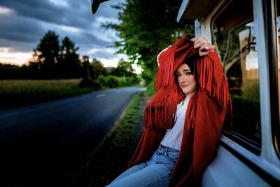 Portrait of young woman standing on road
