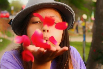 Close-up portrait of young woman with balloons in park