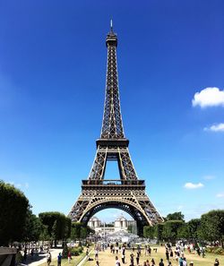 Eiffel tower against blue sky in city on sunny day