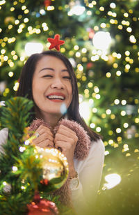 Portrait of young woman with christmas tree