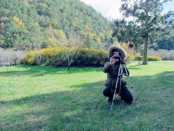 Man photographing on field