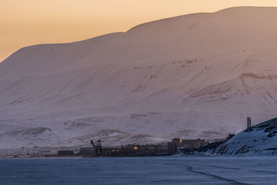 Scenic view of snow covered mountains against sky during sunset