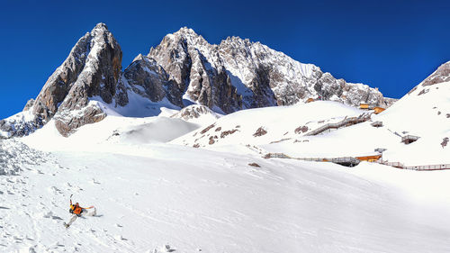 Person skiing on snowcapped mountain against sky