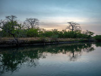 Scenic view of lake against sky at sunset