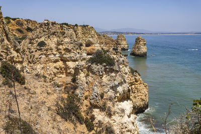 Scenic view of rocks in sea against clear sky