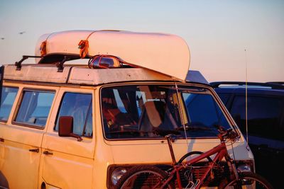 Van with canoe and bicycle attached during sunset