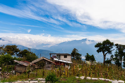 Scenic view of house and mountains against sky