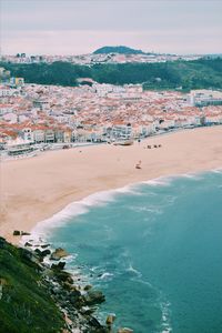 High angle view of beach by city against sky