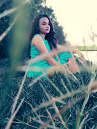 Portrait of beautiful young woman lying on land