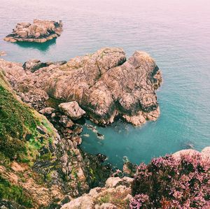 High angle view of rock formations by sea against sky