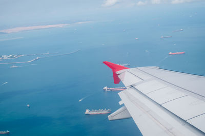 High angle view of airplane wing over sea