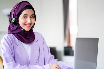 Portrait of young woman using laptop at home