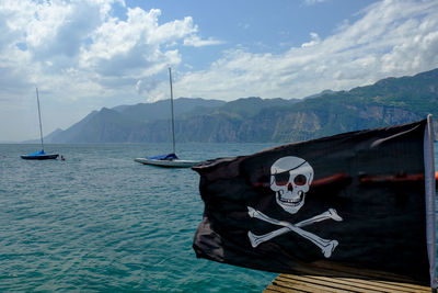Sailboats in sea against sky