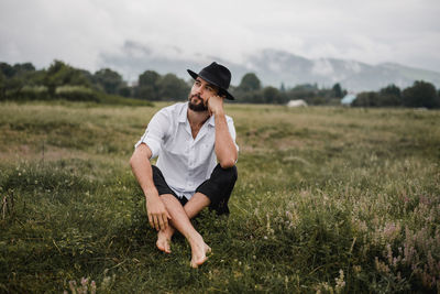 Full length of man sitting on field