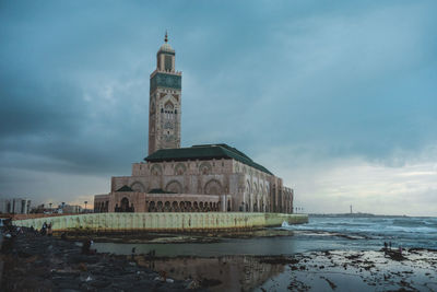 Low angle view of bell tower against cloudy sky