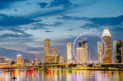 View of the giant ferris wheel and singapore city building background in sunset time 