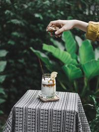 Cropped hand of woman pouring syrup in ice cream