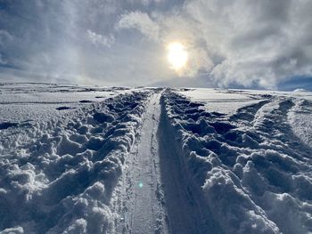 Snow covered road against sky