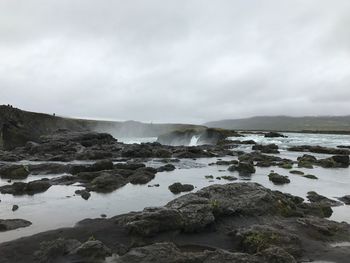 Scenic view of rocks in sea against sky