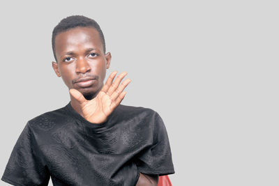 Portrait of young man standing against white background