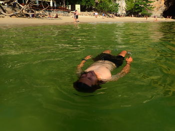 High angle view of man lying in water