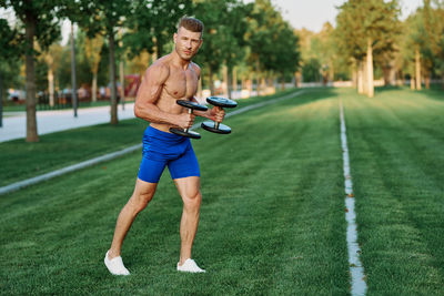 Full length of man exercising on field