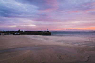 Scenic view of beach against dramatic sky