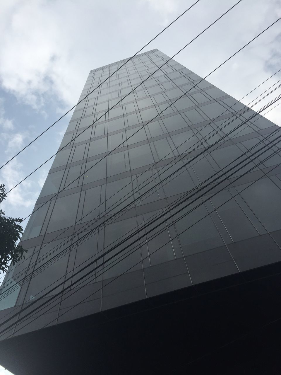 architecture, low angle view, built structure, building exterior, modern, sky, office building, city, skyscraper, tall - high, tower, building, glass - material, day, outdoors, reflection, cable, no people, cloud - sky, cloud