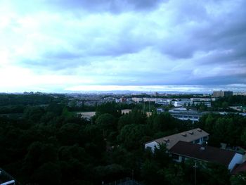 Buildings in town against cloudy sky