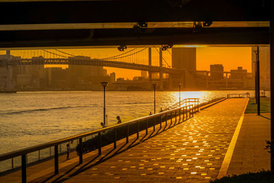 Bridge over river against sky during sunset