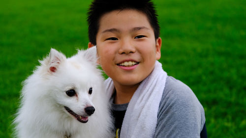 Close-up of smiling cute boy embracing dog