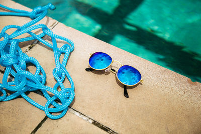 High angle view of rope by sunglasses at poolside
