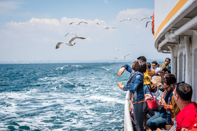 People flying over sea against sky