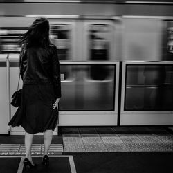 Rear view of woman on train at railroad station