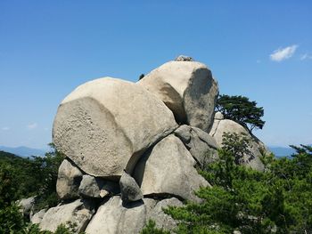 Low angle view of rocks on mountain against clear sky